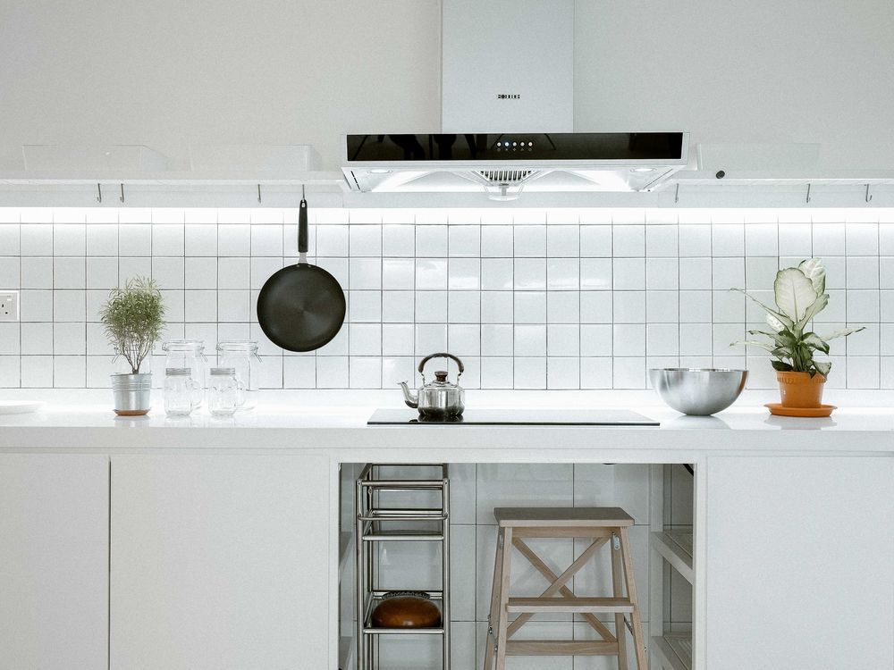 White apartment kitchen with tiled backsplash and open shelving