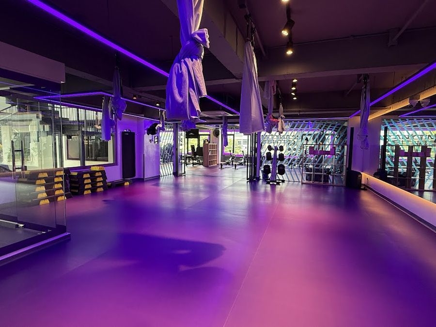 Gym studio with soft flooring, glass partitions and feature lighting