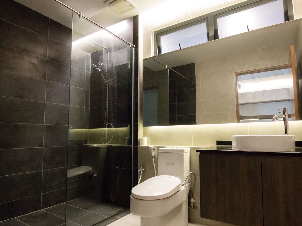 Bathroom with dark wall tiles, glass shower screen and vanity cabinet