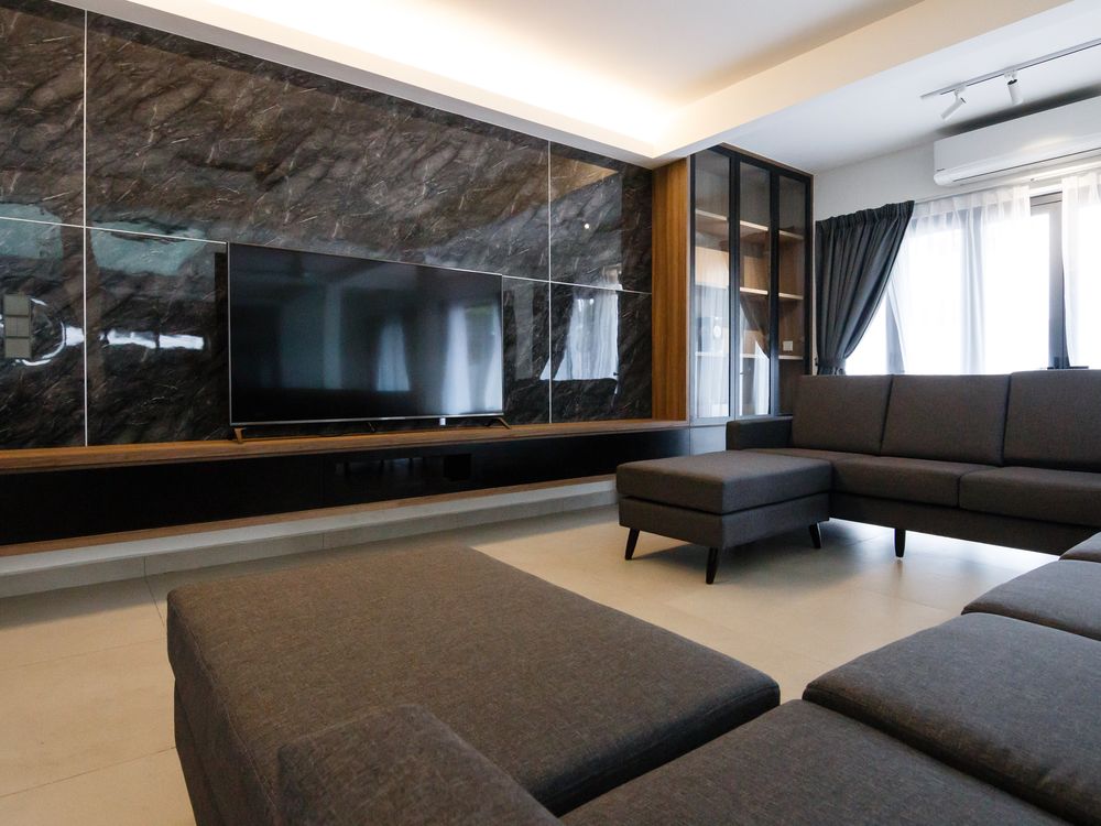 Living area with a stone-look feature wall, built-in TV console and sofas